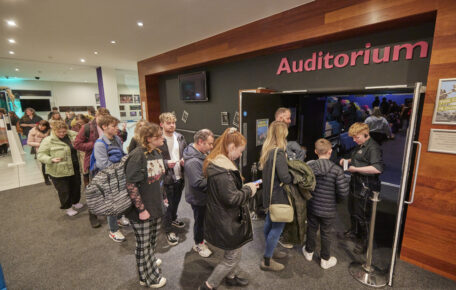 An audience walking into the Lincoln Arts Centre Auditorium