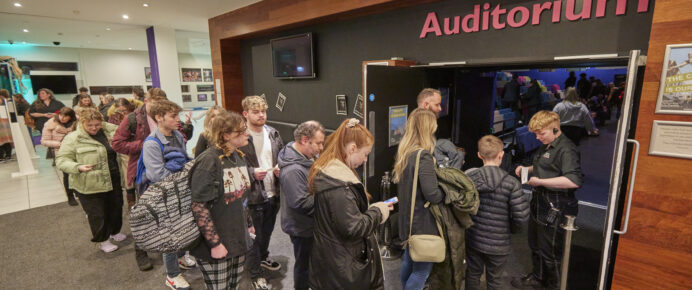 An audience walking into the Lincoln Arts Centre Auditorium