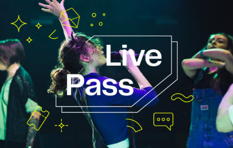 Person singing in a microphone with one hand up in the air, with the Live Pass logo around them.