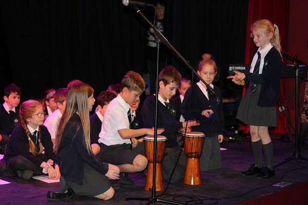 School children playing drums.