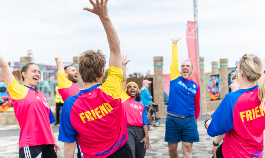 Group of people holding their hands up and smiling.