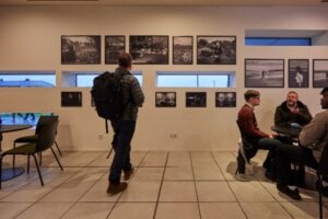 Person looking at photography exhibit in cafe bar.