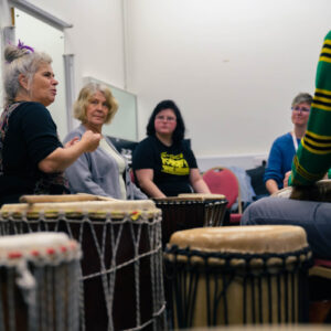 People gathered around drums talking.