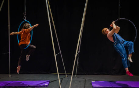 Two people use aerial hoops