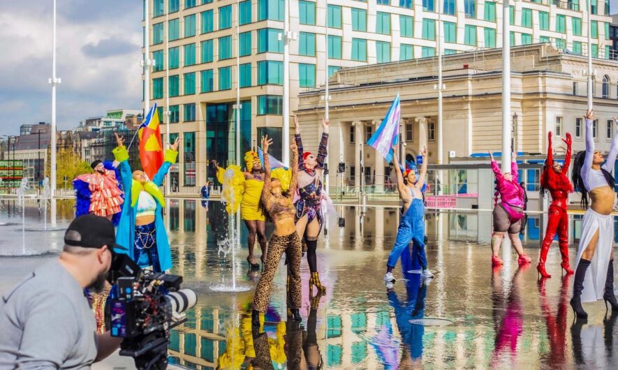 Performers on wet convrete outside being filmed.