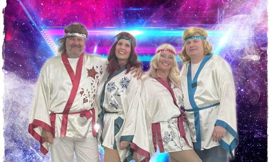 4 performers dressed as Abba stand infront of a pink and blue background.