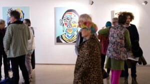 An image of Tinashe's work with a few people in the gallery