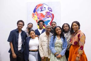 Tinashe with their family in front of one off his paintings.