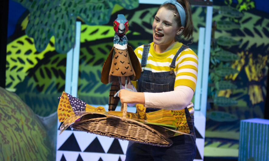Barmpot Theatre on stage with a bird puppet, the performers mouth is open with excitement as they look at the bird.